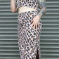 Person wearing a leopard print outfit in front of a metallic shutter.