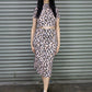 Woman wearing a leopard print outfit standing in front of a metal shutter.