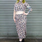 Person wearing a leopard print outfit standing against a metal shutter.
