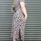Person wearing a leopard print outfit with a green hair against a metal shutter background