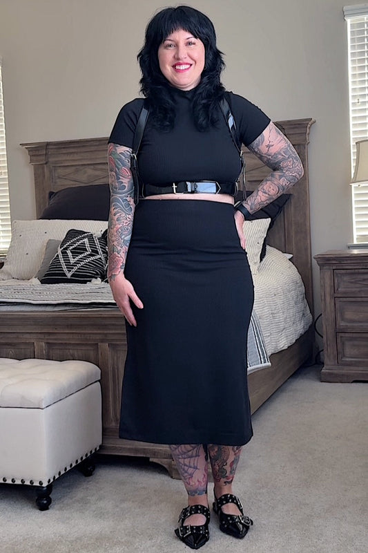 Person wearing a black outfit in a bedroom
