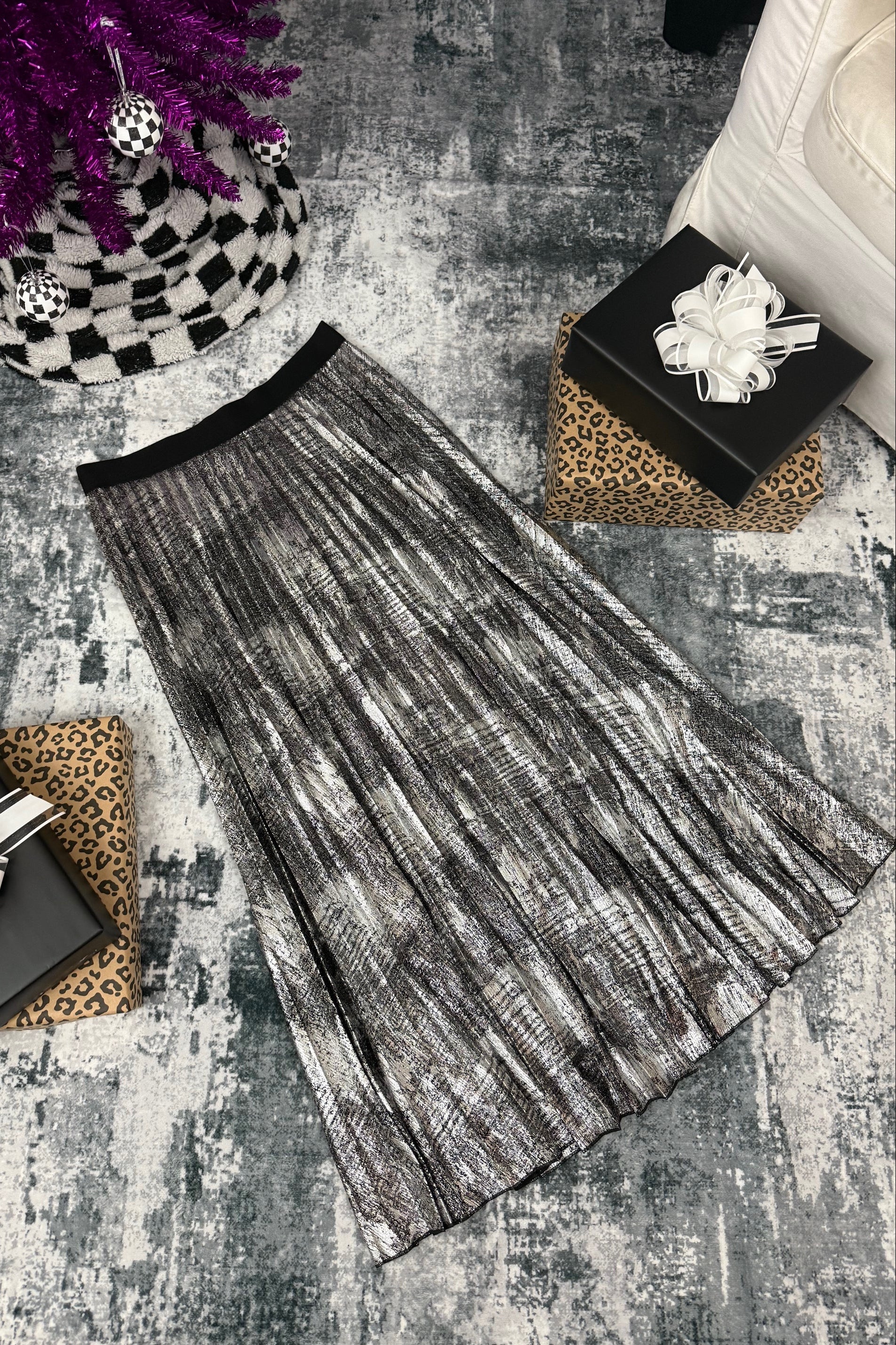 Black and white patterned scarf on a textured surface with decorative items.