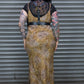 Person wearing a leopard print dress with a black belt against a metal shutter background