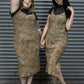 Two women wearing leopard print dresses standing in front of a metal shutter.