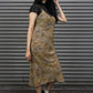 Woman wearing a leopard print dress with black accents against a metallic shutter background