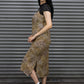 Woman wearing a leopard print dress and black sneakers in front of a metal shutter.