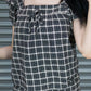 Person wearing a black and white checkered outfit with a blurred background