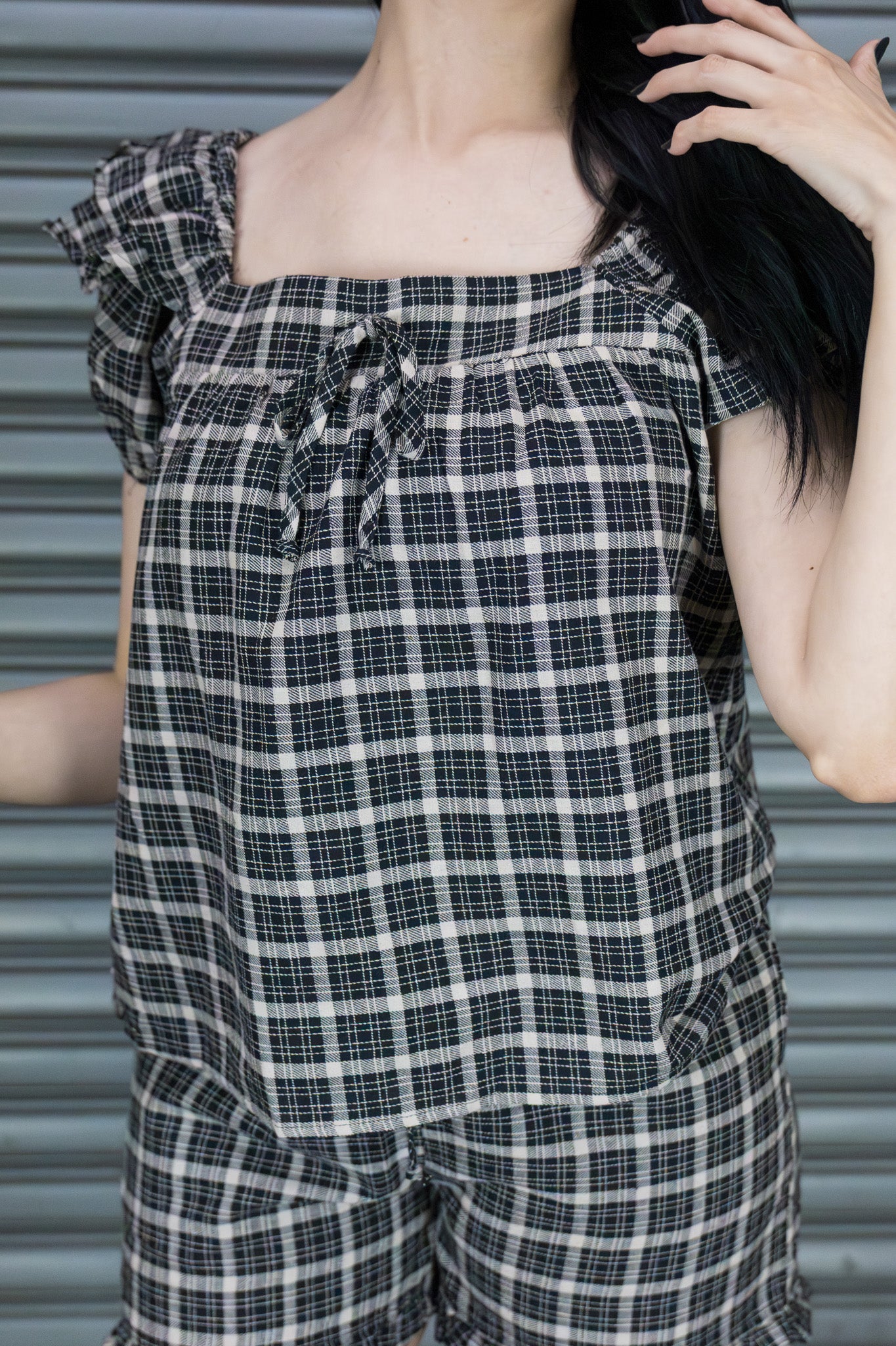 Person wearing a black and white checkered outfit with a blurred background