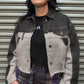 Woman wearing a denim jacket and plaid pants standing in front of a metal shutter.