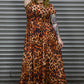 Person wearing a leopard print dress standing against a metallic shutter.
