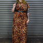 Person wearing a leopard print dress standing in front of a metal shutter.