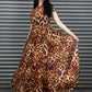 Woman wearing a leopard print dress standing against a metallic shutter.