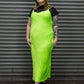 Person wearing a bright green dress against a metallic shutter background