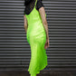 Woman wearing a neon green dress with black accents against a metallic shutter background.