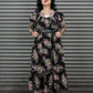 Woman wearing a floral dress standing in front of a metal shutter.