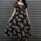 Woman wearing a floral dress standing in front of a metal shutter.