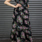 Person wearing a floral dress with a belt against a metallic background