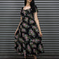 Woman wearing a floral dress standing in front of a metallic shutter.