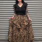 Person holding a leopard print skirt smiling.