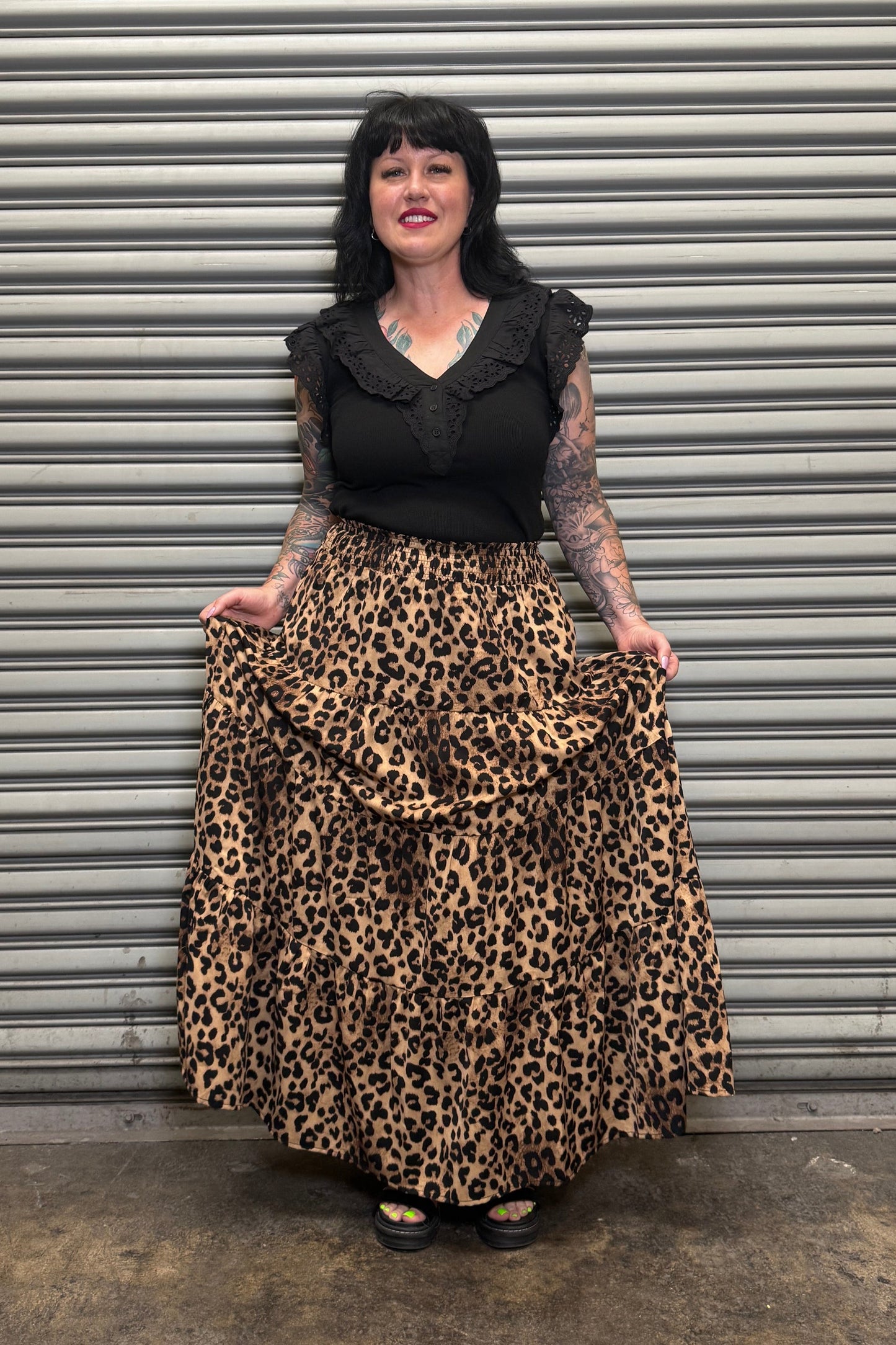 Person holding a leopard print skirt smiling.