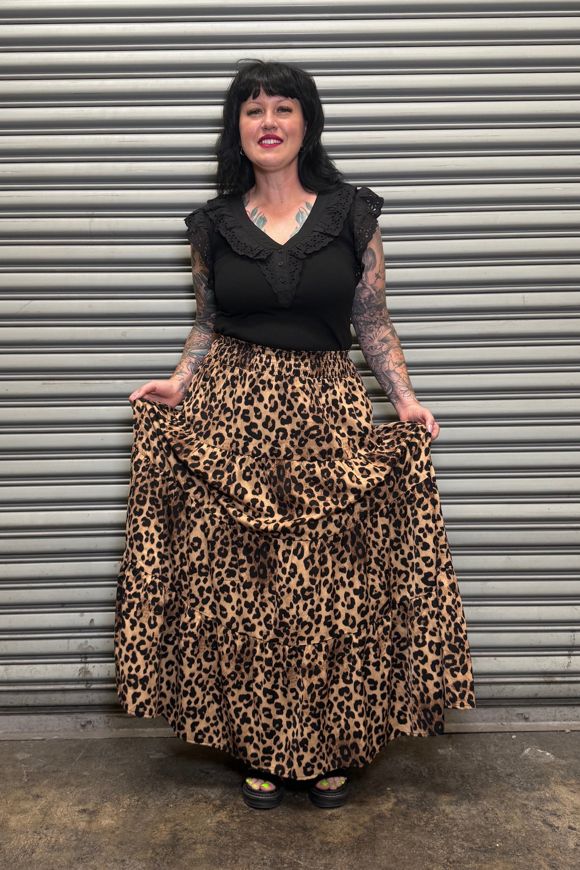 Person holding a leopard print skirt smiling.
