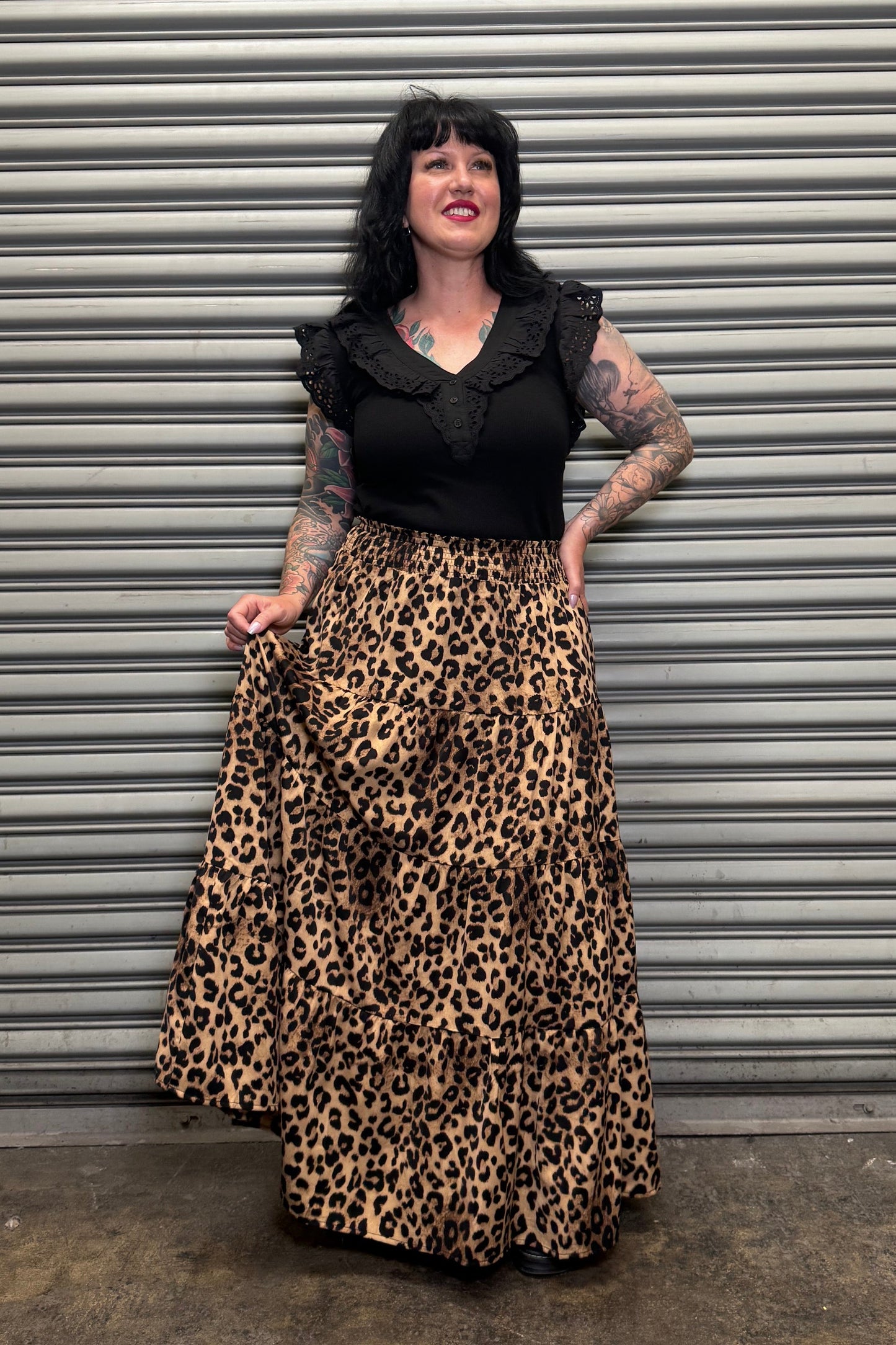 Person wearing a black outfit with a leopard print skirt .