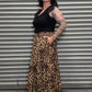 Side view of the Wild Heart leopard print tiered maxi skirt with pockets paired with a black ruffle sleeve top.